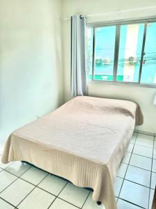 un lit dans une chambre avec une fenêtre dans l'établissement Apartamento no Centro Balneário Camboriú, à Balneário Camboriú