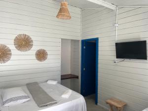 Dieses Zimmer verfügt über ein Bett mit einem TV und ein Bett der Marke sidx sidx sidx. in der Unterkunft Casa Garça - 4 Suítes - Super Piscina - Pé na Areia - em Maceió in Maceió