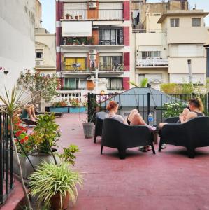 un grupo de personas sentadas en sillas en un balcón en Voyage Recoleta Hostel en Buenos Aires