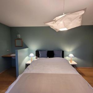 1 dormitorio con 1 cama grande y edredón blanco en Les Roses de François, en Vaux-sur-Sûre