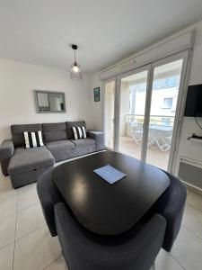 a living room with a table and a couch at Appartement avec Terrasse et box in Marseille