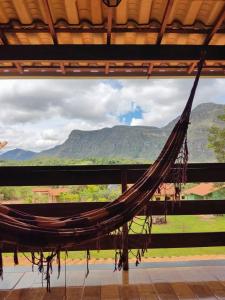 uma rede de descanso num quarto com vista para as montanhas em Pousada Bela Vista do Ismail - Lapinha da Serra em Santana do Riacho