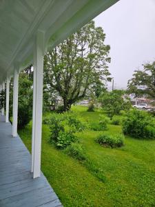 une terrasse couverte d'une maison avec une cour verdoyante dans l'établissement Sunflower Guest Suites, à Summerside