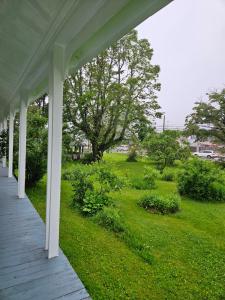 un porche de una casa con un patio verde en Sunflower Guest Suites en Summerside