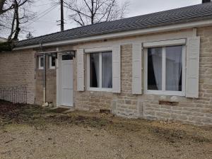 a brick house with two windows and a white door at Au petit logement in Soncourt-sur-Marne