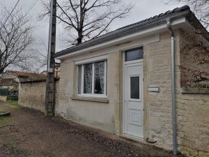 un pequeño edificio con puerta y ventana en Au petit logement, en Soncourt-sur-Marne