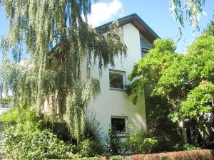 una casa blanca con árboles delante de ella en Freiburg citynah - hell, ruhig, gemütlich, en Freiburg im Breisgau