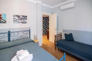 1 dormitorio con 1 cama azul y 1 sofá en U MAE MA, UN PASSO DAL MARE, en Bogliasco