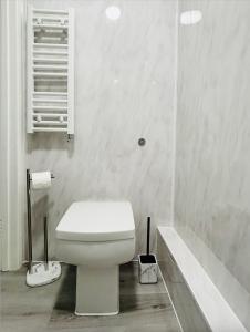 y baño blanco con aseo y bañera. en Kensington Secret Gem, en Londres
