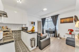 Il dispose d'une cuisine et d'un salon avec un canapé et une table. dans l'établissement Central London Oxford Street One Bedroom Apartment, à Londres