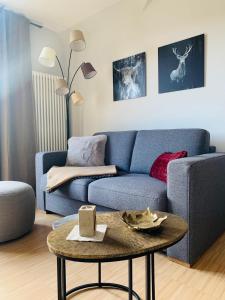 a living room with a blue couch and a table at Ferienwohnung Villa Grützner in Freital