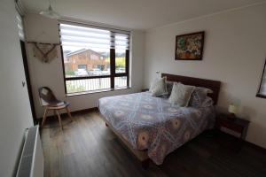 1 dormitorio con cama y ventana grande en TuArriendoCL-MPHA106 Gran Depto en Pto Varas 3D2B 6PAX sin vista primer piso con jardin, en Puerto Varas