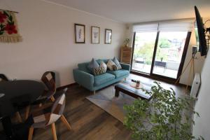 uma sala de estar com um sofá azul e uma mesa em TuArriendoCL-MPHA106 Gran Depto en Pto Varas 3D2B 6PAX sin vista primer piso con jardin em Puerto Varas