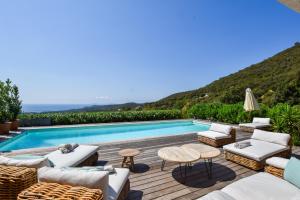 een villa met een zwembad en een patio bij Villa Les Agrumes vue panoramique sur mer in La Croix-Valmer