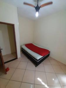 uma cama num quarto com uma ventoinha de tecto em Excelente Localização em Jacaraípe em Serra