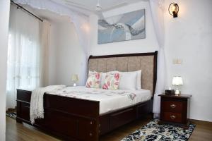 a bedroom with a large bed with white walls at Zuri Luxe 2BR Penthouse- Silversands Beach Malindi in Malindi +44 photos