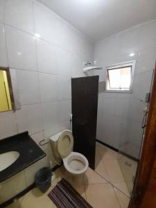 uma casa de banho com um WC e um lavatório em Excelente Localização em Jacaraípe em Serra