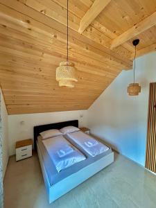 a bedroom with a bed with a wooden ceiling at ALPS Apartments in Kranjska Gora