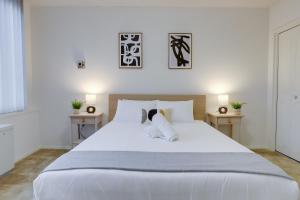 - une chambre avec un grand lit blanc et 2 tables dans l'établissement Sensational Condominium @Crystal City, à Arlington