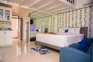 een slaapkamer met een wit bed en een blauwe stoel bij Czar's Oasis Apt B27 @ Ocho Rios in Ocho Rios