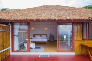 a room with a bed and a thatch roof at Cozy Homey Doichang in Ban Muang Ngam