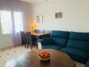 uma sala de estar com um sofá e uma mesa com uma tigela de laranjas em Apartment-House La Mata Torrevieja em Torrevieja