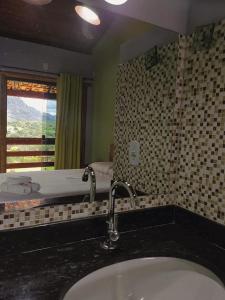 ein Bad mit einem Waschbecken und einem Fenster in der Unterkunft Pousada Bela Vista do Ismail - Lapinha da Serra in Santana do Riacho