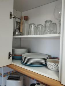 a cupboard filled with plates and other dishes at Apartamentos Pirra - Aeropuerto Ifema in Madrid