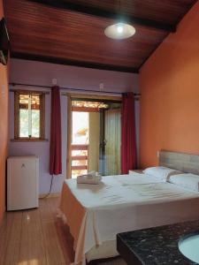 sypialnia z dużym łóżkiem i oknem w obiekcie Pousada Bela Vista do Ismail - Lapinha da Serra w mieście Santana do Riacho