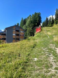 una cometa roja sentada en la cima de una colina pastosa en Appartamento - Residence I Larici en Folgarida