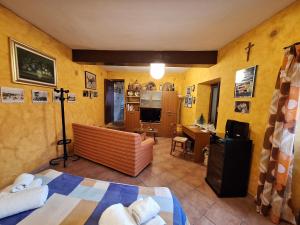 Cette chambre comprend un lit et un bureau. dans l'établissement A Casa da Nonna Brasa Holiday Home Savoca, à Savoca