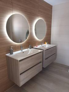 La salle de bains est pourvue de 2 lavabos et de 2 miroirs. dans l'établissement Cozy duplex in old town Ondara, à Ondara