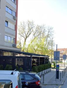 um parque de estacionamento com carros estacionados em frente a um edifício em Martin’s flat in the city centre em Ljubljana