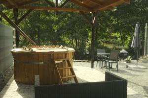 een grote houten bar met een tafel en stoelen bij Le Rotche I in La-Roche-en-Ardenne