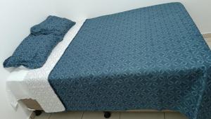 a bed with a blue comforter on top of it at ParadaHome in San Ramón