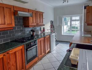 a kitchen with wooden cabinets and a stove top oven at Spacious Retreat - Remote Worker & Family Friendly in Portsmouth