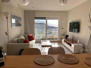 ein Wohnzimmer mit einem Sofa und einem Tisch mit Stühlen in der Unterkunft The New Suite Agaete & Parking in Agaete