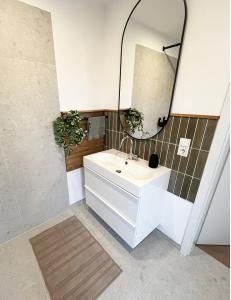 ein Badezimmer mit Waschbecken und Spiegel in der Unterkunft FeWo Anders - Neubau mit Balkon im Bergischen Land in Reichshof 