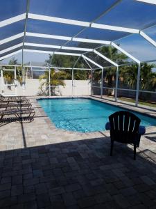a swimming pool with a pavilion and a bench next to it at Abode Villas in Cape Coral