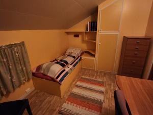 a small bedroom with a bed and a dresser at Tromtind Lodge in Tromsø