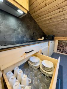 una cucina con piatti e stoviglie in un cassetto di Bormio House con vista pista Stelvio a Bormio