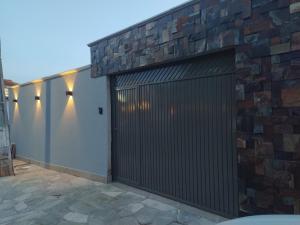 una porta da garage in metallo con un muro in pietra di Casa Pirenópolis a Pirenópolis