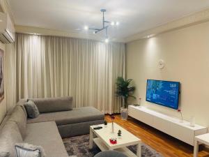 a living room with a couch and a flat screen tv at Mokattem private Condo in Cairo