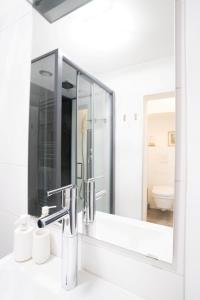 baño con espejo y lavabo en Moderne 2-Zimmer Wohnung, en Gratwein