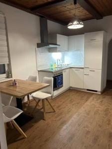 eine Küche mit einem Holztisch sowie einem Tisch und Stühlen in der Unterkunft Schönes Haus in Sankt Pölten