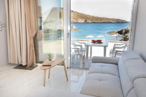 a living room with a couch and a view of the ocean at Beachfront Studio Kyma East ~ Crete's Hidden Gem in Kali Limenes