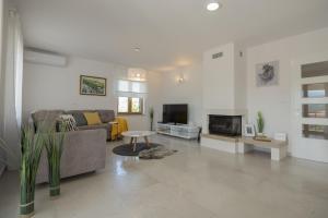 a living room with a couch and a tv at Villa In Excelsis in Imotski