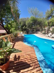 a wooden deck next to a swimming pool at Complejo de Cabañas Estancia Del Águila in Mina Clavero