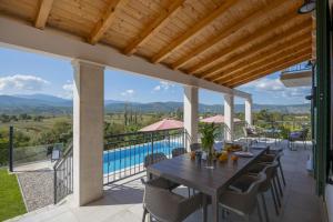 an outdoor patio with a table and chairs and a pool at Villa In Excelsis in Imotski