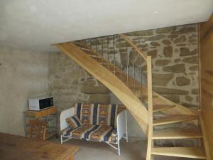 a wooden staircase in a room with a stone wall at Studio Le Plancher in Bathernay